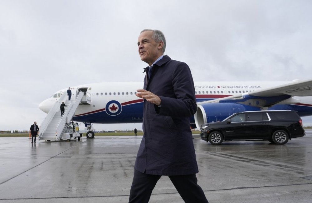Prime Minister Mark Carney speaks with members of the media before he boards a government plane in Ottawa on Friday, Oct. 24, 2025. THE CANADIAN PRESS/Adrian Wyld
