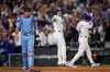 Philadelphia Phillies catcher J.T. Realmuto, left, walks off the field after Los Angeles Dodgers' Hyeseong Kim, right, scored the game-winning run on a ground ball from Andy Pages and throwing error from Phillies pitcher Orion Kerkering during the eleventh inning in Game 4 of baseball's National League Division Series Thursday, Oct. 9, 2025, in Los Angeles. (AP Photo/Mark J. Terrill)