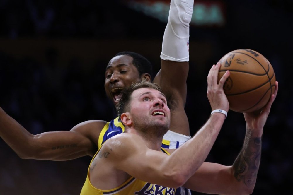Los Angeles Lakers guard Luka Doncic (77) attempts a shot against the Golden State Warriors during the second half of an NBA basketball game Tuesday, Oct. 21, 2025, in Los Angeles. (AP Photo/Ethan Swope)
