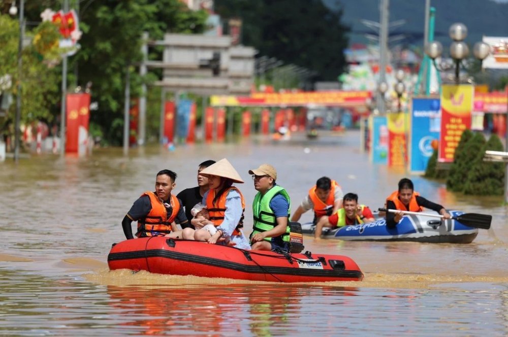 Local residents travel by boat on a flooded street in the aftermath of typhoon Matmo in Thai Nguyen, Vietnam, Wednesday, Oct. 8, 2025. (Nguyen Quang Hai/VNA via AP)
