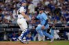 Toronto Blue Jays' Daulton Varsho scores on an RBI sacrifice fly by Ernie Clement during the fourth inning in Game 5 of baseball's World Series as Los Angeles Dodgers' Will Smith, left, waits for the throw, Wednesday, Oct. 29, 2025, in Los Angeles. (AP Photo/Ashley Landis)