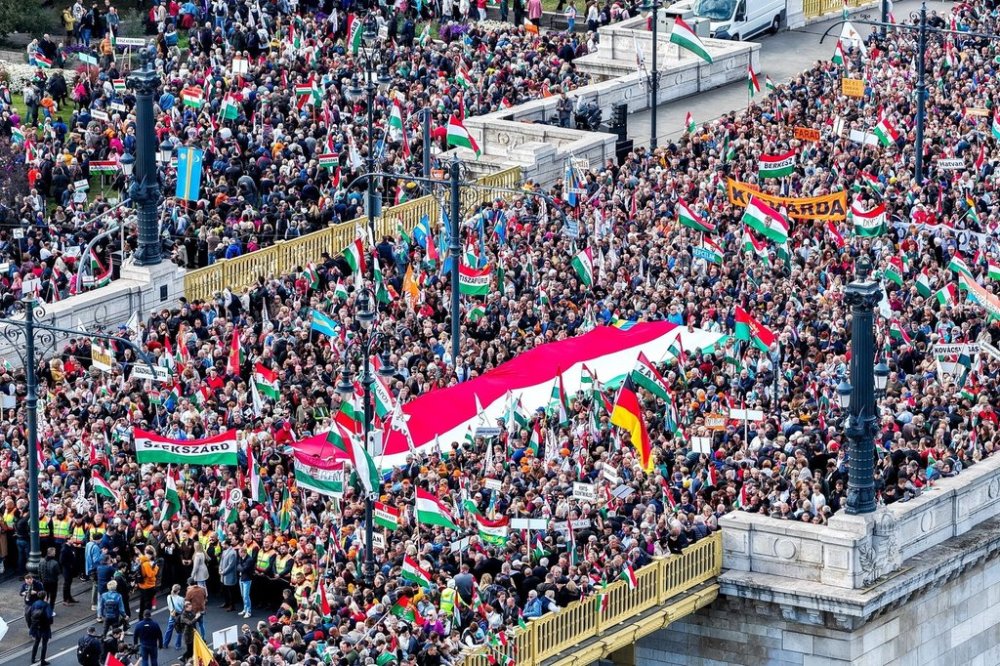 In this photo taken by a drone, participants of the Peace March organized by the pro-government Civil Unity Forum (COF) and its foundation Civil Unity Public Benefit Foundation (COKA) gather at the Buda side of Margaret Bridge in Budapest, Hungary, Thursday, Oct. 23, 2025, on the 69th anniversary of the Hungarian revolution and war of independence against communist rule and the Soviet Union in 1956. (Zsolt Czegledi/MTI via AP)