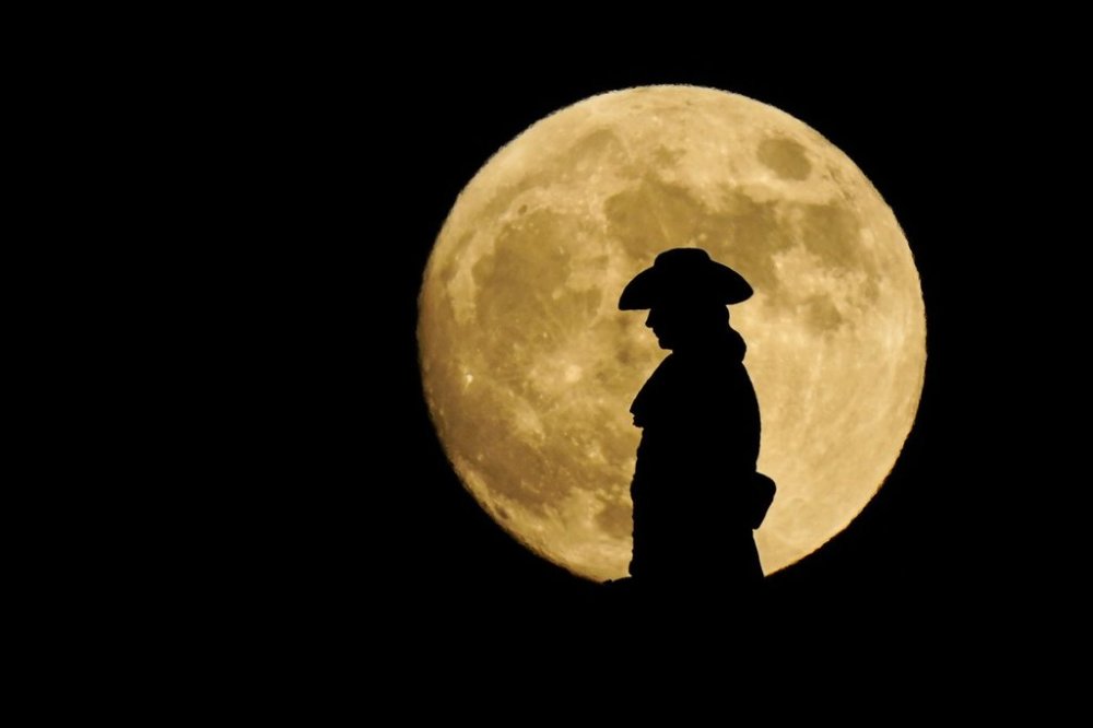FILE - A strawberry full moon rises behind a statue of William Penn atop City Hall in Philadelphia, Thursday, June 24, 2021. (AP Photo/Matt Rourke, File)