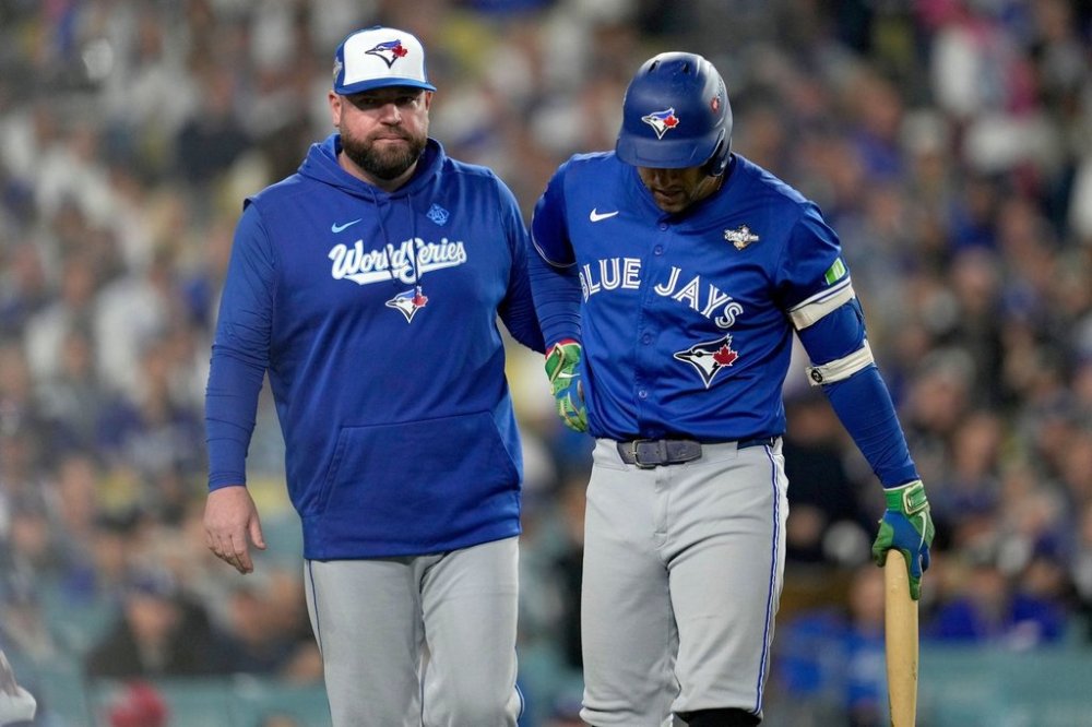 Toronto Blue Jays manager John Schneider helps George Springer off the field after he suffered an injury in the seventh inning of Game 3 of the World Series against the Dodgers on Oct. 27, 2025, in Los Angeles. (AP Photo/Ashley Landis)