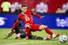 Australia's Nestory Irankunda (bottom) shoots past Canada's Niko Sigur (23) to score during second half international friendly soccer action in Montreal, on Friday, October 10, 2025. THE CANADIAN PRESS/Christopher Katsarov