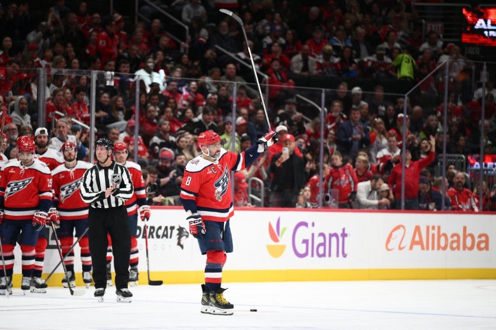 Washington Capitals left wing Alex Ovechkin (8) raises his stick to the crowd after he was recognized for playing in his 1,500th NHL hockey game during a break in the action in the first period against the Ottawa Senators, Saturday, Oct. 25, 2025, in Washington. (AP Photo/Nick Wass)