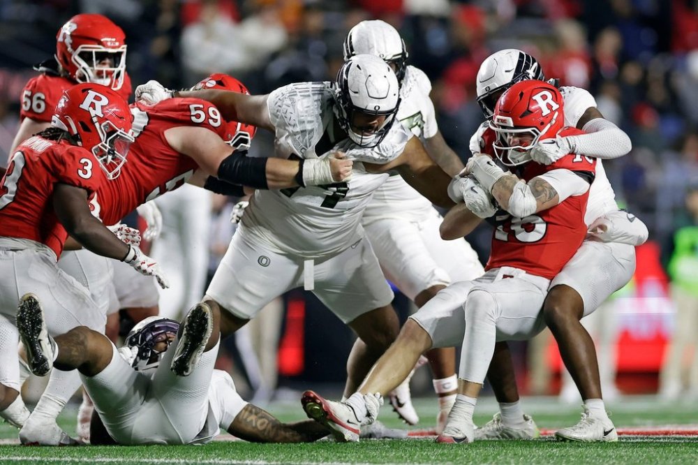 Rutgers quarterback Athan Kaliakmanis, front right, is sacked by Oregon linebacker Dylan Williams, back right, during the second half of an NCAA college football game Saturday, Oct. 18, 2025, in Piscataway, N.J. (AP Photo/Adam Hunger)