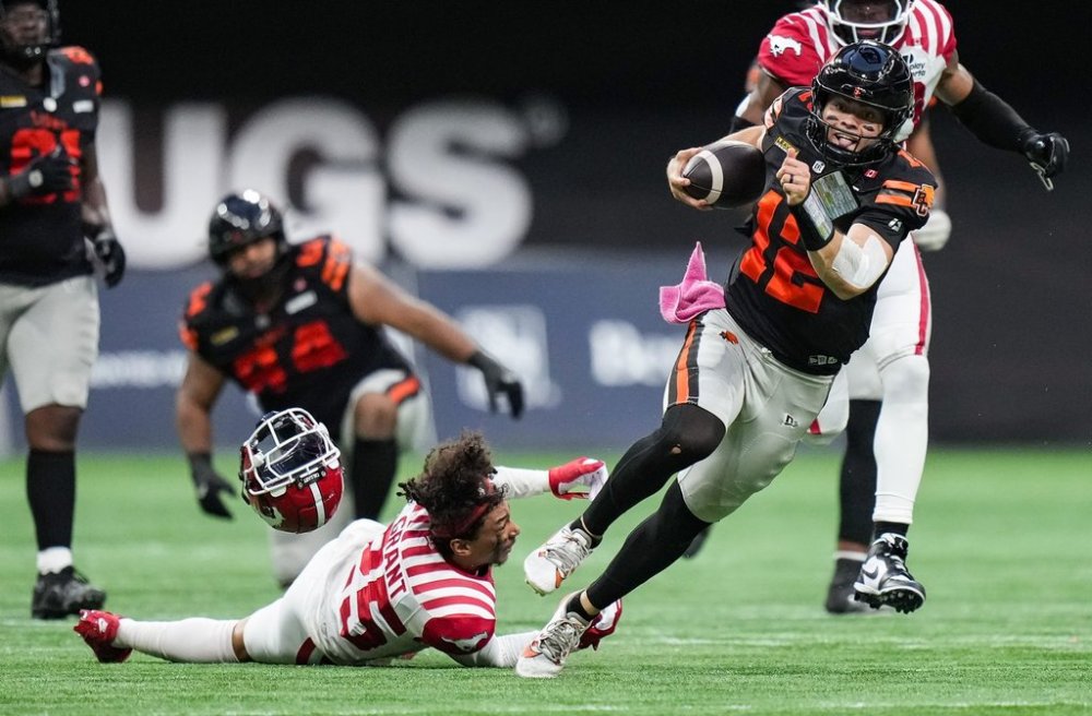 B.C. Lions quarterback Nathan Rourke (12) gets away from Calgary Stampeders' Jaydon Grant (25), as he loses his helmet, during the second half of a CFL football game, in Vancouver, on Saturday, Oct. 4, 2025. THE CANADIAN PRESS/Darryl Dyck