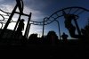 Children play on the monkey bars outside Funston Elementary School as night falls, in Chicago's Logan Square neighborhood, Thursday, Oct. 16, 2025. (AP Photo/Rebecca Blackwell)