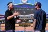 Milwaukee Brewers' Brandon Woodruff, left talks with Brice Turang ahead of Game 3 of baseball's National League Championship Series against the Los Angeles Dodgers, Wednesday, Oct. 15, 2025, in Los Angeles. (AP Photo/Mark J. Terrill)