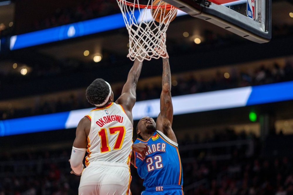 Oklahoma City Thunder guard Cason Wallace (22), right, attempts a basket against Atlanta Hawks forward/center Onyeka Okongwu (17) during the first half of an NBA basketball game , Saturday, Oct. 25, 2025, in Atlanta. (AP Photo/Erik Rank)
