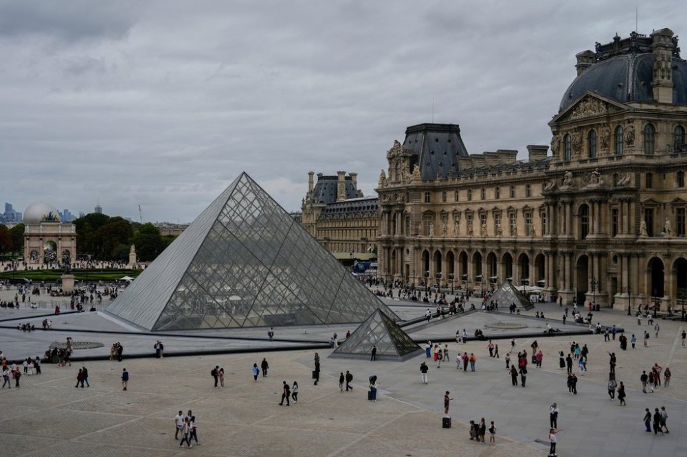 FILE - People walk outside the Louvre museum, Sunday, Aug. 31, 2025, in Paris. (AP Photo/Julia Demaree Nikhinson, File)