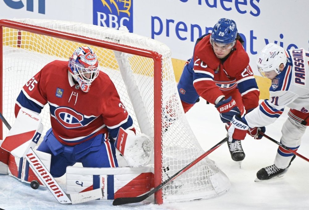 Montreal Canadiens' Juraj Slafkovsky (20) defends against and New York Rangers' Juuso Parssinen (71) as he tries a wraparound on Canadiens goaltender Sam Montembeault (35) during first period NHL hockey action in Montreal, Saturday, Oct. 18, 2025. THE CANADIAN PRESS/Graham Hughes