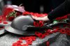 A person touches the helmet on the Tomb of the Unknown Soldier after laying a poppy, at the National War Memorial after the National Remembrance Day Ceremony in Ottawa, on Friday, Nov. 11, 2022. THE CANADIAN PRESS/Justin Tang
