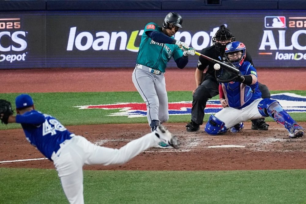 Seattle Mariners Jorge Polanco connects for an RBI single as Toronto Blue Jays pitcher Seranthony Domínguez (48) follows through during the eighth inning in Game 1 of baseball's American League Championship Series, Sunday, Oct. 12, 2025, in Toronto. (AP Photo/David J. Phillip)