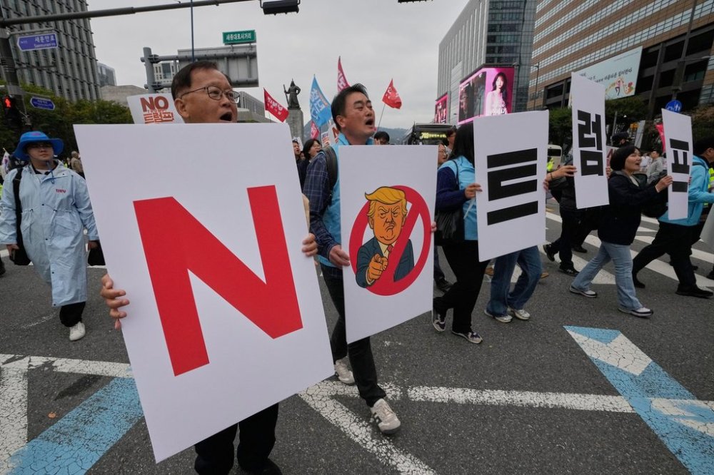 FILE - South Korean protesters march during a rally against U.S. President Donald Trump's tariffs policy on South Korea, in Seoul, South Korea, Oct. 18, 2025. The signs read