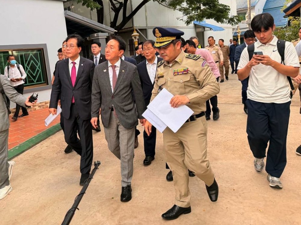 In this photo released by Agence Kampuchea Press (AKP), a delegation of South Korean lawmakers, left, visit a building complex that was allegedly used for online scam work, outside Phnom Penh, Cambodia, Wednesday, Oct. 22, 2025. (AKP via AP)