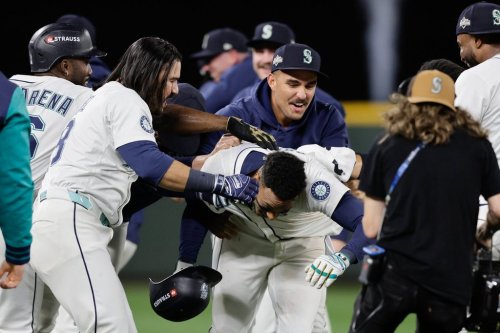 Seattle Mariners players celebrate with Jorge Polanco, center, after he hit the game-winning RBI single in the 15th inning in Game 5 of baseball's American League Division Series against the Detroit Tigers, Friday, Oct. 10, 2025, in Seattle. (AP Photo/John Froschauer)