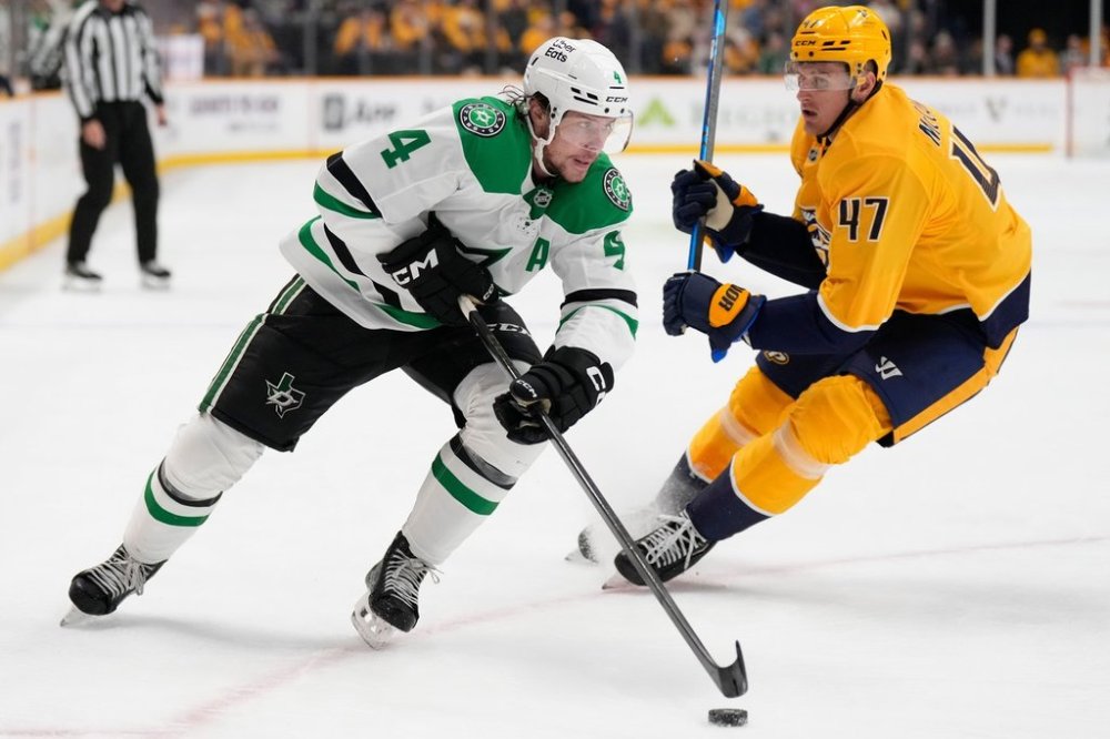 Dallas Stars defenseman Miro Heiskanen (4) skates the puck past Nashville Predators right wing Michael McCarron (47) during the first period of an NHL hockey game Sunday, Oct. 26, 2025, in Nashville, Tenn. (AP Photo/George Walker IV)