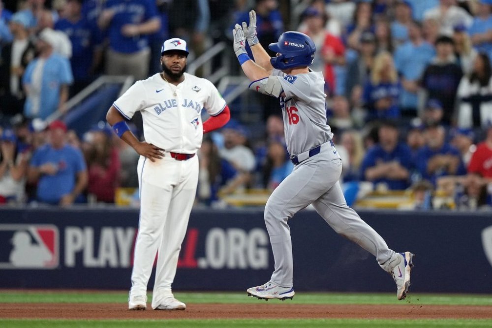 Toronto Blue Jays first baseman Vladimir Guerrero Jr. (27) looks on as Los Angeles Dodgers catcher Will Smith (16) rounds the bases after hitting a solo home run during the seventh inning of MLB's Game 2 World Series playoff action against the Toronto Blue Jays, in Toronto, Saturday, Oct. 25, 2025. THE CANADIAN PRESS/Nathan Denette