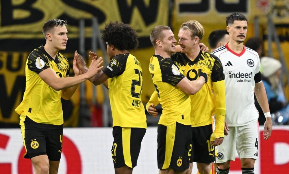From left, Dortmund's Nico Schlotterbeck, Karim Adeyemi, Julian Ryerson and scorer Julian Brandt celebrate their side's first goal during a German soccer cup second round match between Eintracht Frankfurt and Borussia Dortmund in Frankfurt, Germany, Tuesday, Oct. 28, 2025. (Arne Dedert/dpa via AP)