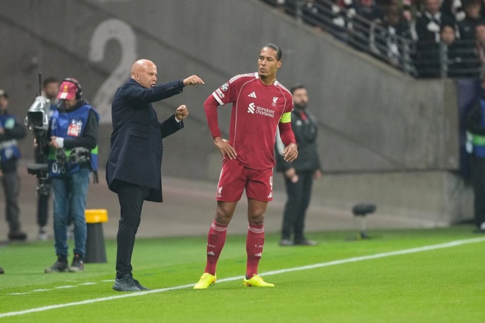 Liverpool's manager Arne Slot, left, talks to Virgil van Dijk during the Champions League opening phase soccer match between Eintracht Frankfurt and Liverpool in Frankfurt, Germany, Wednesday, Oct. 22, 2025. (AP Photo/Michael Probst)