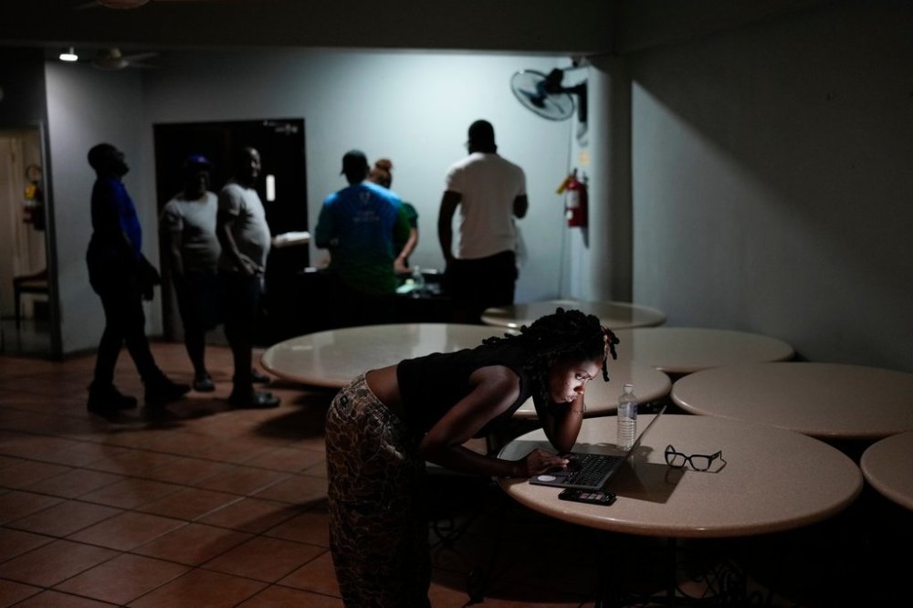 A woman video chats with a friend ahead of Hurricane Melissa's forecast arrival in Kingston, Jamaica, Monday, Oct. 27, 2025. (AP Photo/Matias Delacroix)
