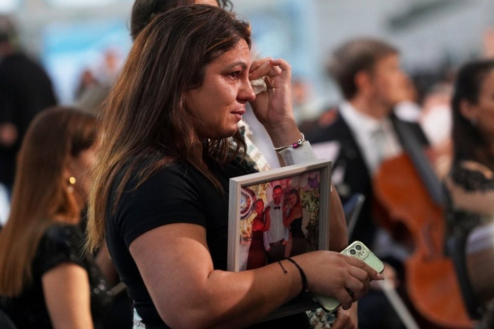 Relatives of victims react during a memorial ceremony marking one year since floods that killed more than 230 people, in Valencia, Spain, Wednesday, Oct. 29, 2025. (AP Photo/Alberto Saiz)