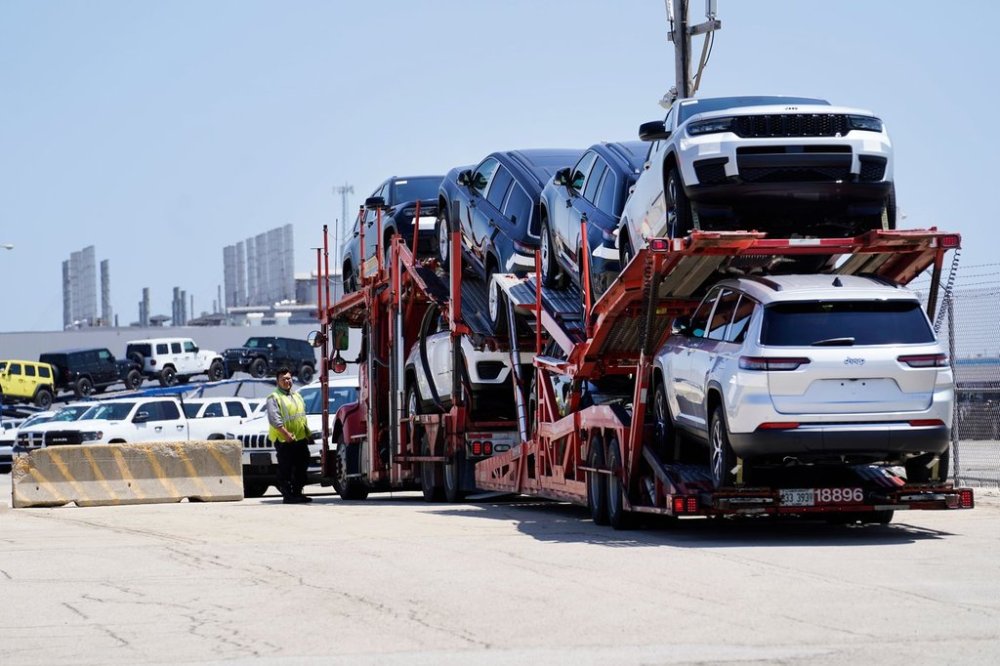 FILE - A transport carrying new cars arrives at a Stellantis facility July 10, 2023, in Belvidere. Ill. (AP Photo/Charles Rex Arbogast, File)