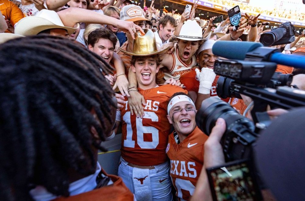 Texas quarterback Arch Manning (16) and defensive back Michael Taaffe, center bottom, celebrate with fans after defeating Oklahoma in an NCAA college football game Saturday, Oct. 11, 2025, in Dallas. (AP Photo/Jeffrey McWhorter)