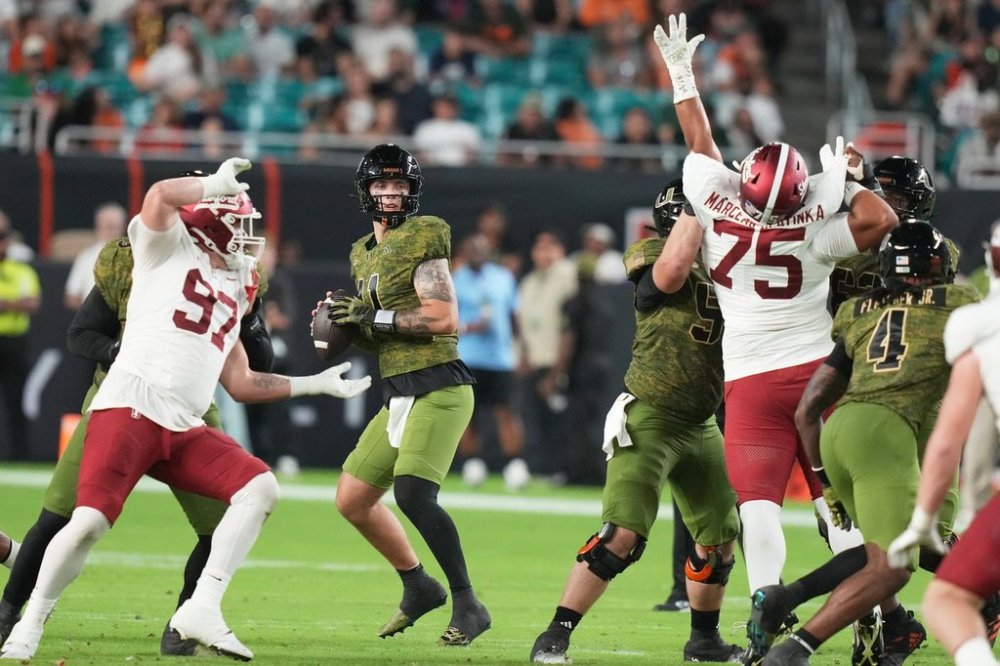 Miami quarterback Carson Beck, center, stands back to pass during the first half of an NCAA college football game against Stanford, Saturday, Oct. 25, 2025, in Miami Gardens, Fla. (AP Photo/Lynne Sladky)