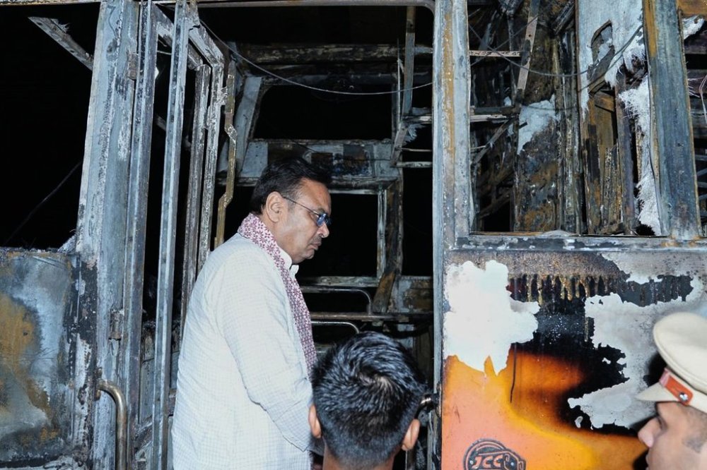 This photograph shared by Indian State Rajasthan Chief Minister's office shows Chief Minister Bhajan Lal Sharma inspecting a charred passenger bus after a suspected short circuit sparked a deadly bus fire near Jaisalmer, India, Tuesday, Oct. 14, 2025. (Rajasthan Chief Minister's office via AP)