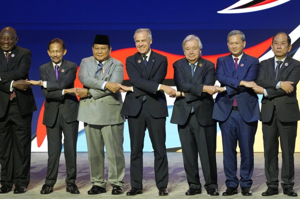 Prime Minister Mark Carney, centre, shakes hands with other leaders during the opening ceremony at the ASEAN summit in Kuala Lumpur, Malaysia, Sunday, Oct. 26, 2025. THE CANADIAN PRESS/Adrian Wyld