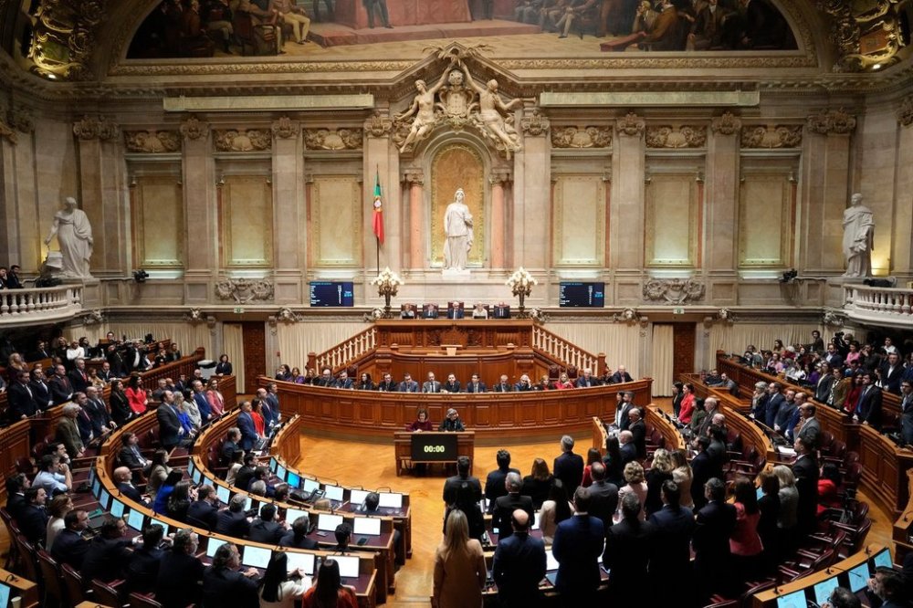 FILE - Members of opposition parties stand to vote against a government confidence motion at the Portuguese parliament in Lisbon, Tuesday, March 11, 2025. (AP Photo/Armando Franca, file)