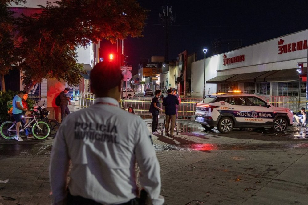 Policeman stands near a convenience store destroyed by a fire in Hermosillo, Sonora state, Mexico, Saturday, Nov. 1, 2025. (AP Photo/Abraham Tellez)
