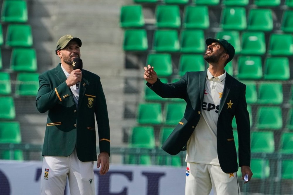 Pakistan's Shan Masood, right, flips the coin for toss as South Africa's Aiden Markram watches before the start of the play of the first test cricket match between Pakistan and South Africa, in Lahore, Pakistan, Sunday, Oct. 12, 2025. (AP Photo/K.M. Chaudary)