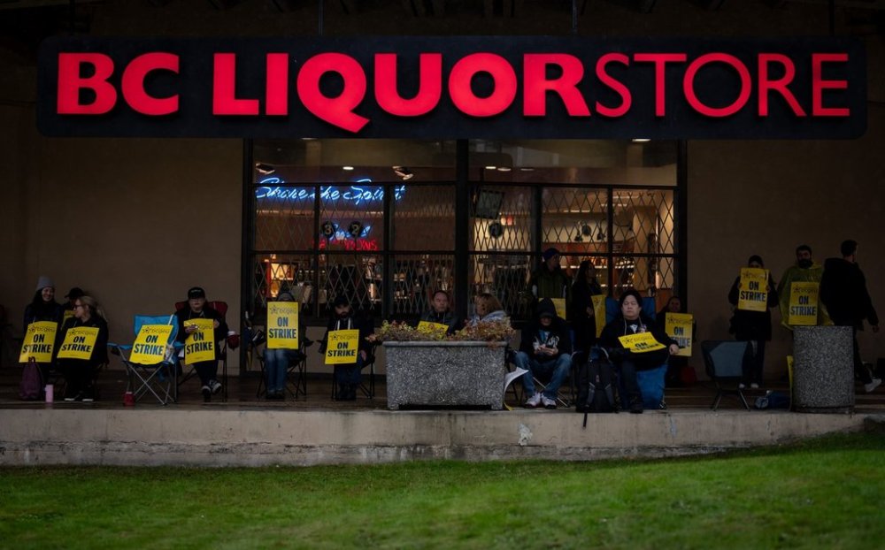 B.C. General Employees' Union (BCGEU) members sit outside of a B.C. provincial liquor store in Vancouver, on Friday, Oct. 10, 2025. THE CANADIAN PRESS/Ethan Cairns