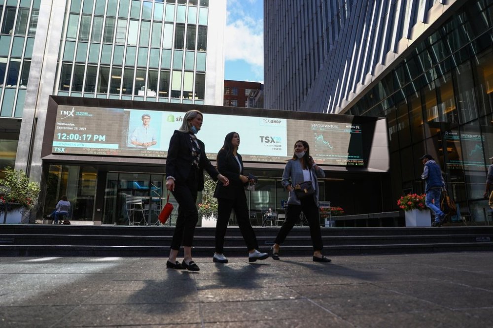 A sign board displays the TSX as women walk past the Richmond Adelaide Centre in the financial district in Toronto on Wednesday, Sept. 29, 2021. THE CANADIAN PRESS/Evan Buhler