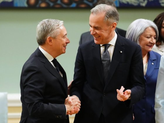 Prime Minister Mark Carney, right, shakes hands with Finance Minister Francois Philippe-Champagne in March. (Sean Kilpatrick / The Canadian Press files)