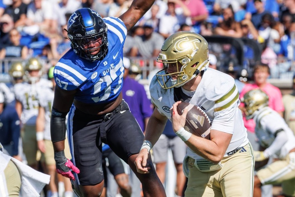 Georgia Tech's Haynes King, right, carries the ball ahead of Duke's Wesley Williams (97) during the second half of an NCAA college football game in Durham, N.C., Saturday, Oct. 18, 2025. (AP Photo/Ben McKeown)