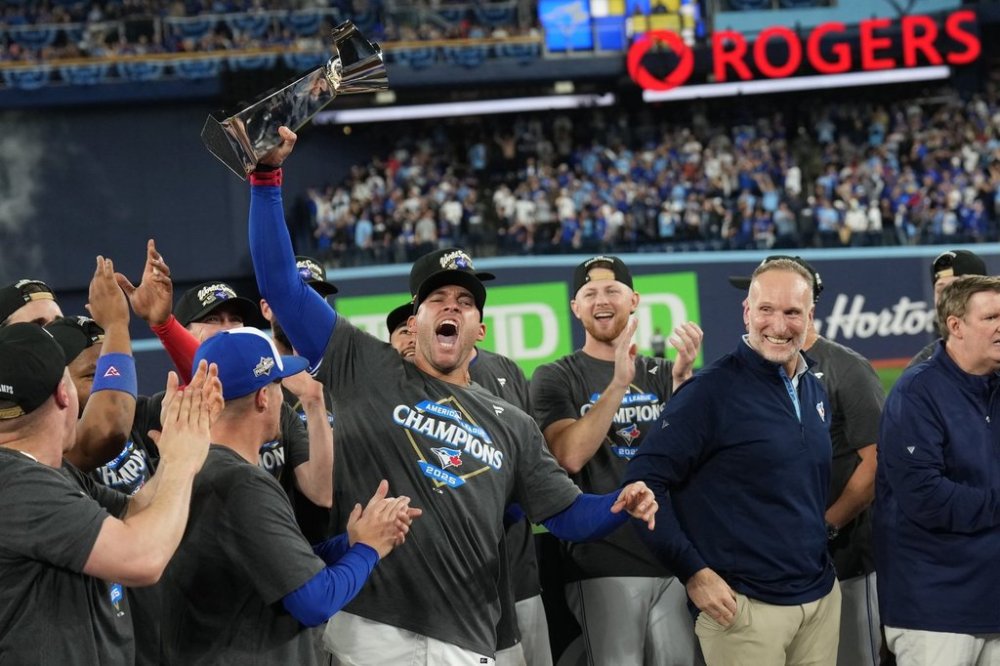 Toronto Blue Jays outfielder George Springer holds the American League Championship Series trophy as the Blue Jays celebrate after defeating the Seattle Mariners in MLB American League Championship Series Game 7 baseball action in Toronto, Monday, Oct. 20, 2025. THE CANADIAN PRESS/Nathan Denette