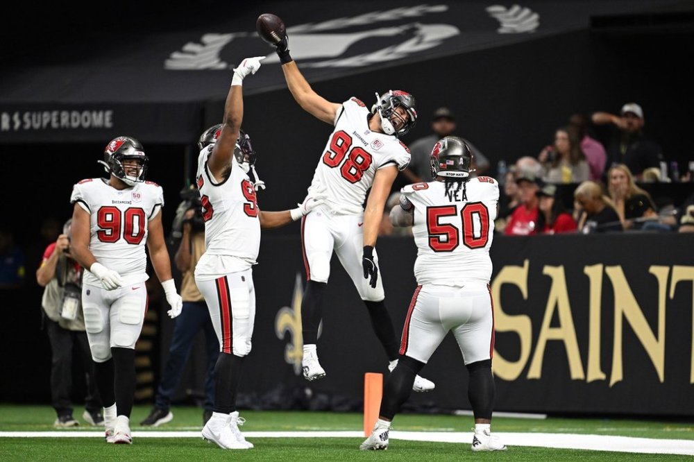 Tampa Bay Buccaneers linebacker Anthony Nelson (98) celebrates, including defensive tackle Vita Vea (50), defensive end Logan Hall (90) and defensive end Elijah Roberts (95) with teammates after returning an interception for a score during the first half of an NFL football game against the New Orleans Saints Sunday, Oct. 26, 2025, in New Orleans. (AP Photo/Ella Hall)