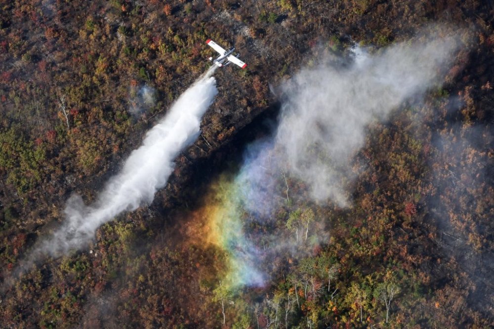 A plane from the Northwest Territories makes a drop over the Lake George wildfire near Aylesford, N.S. in this Friday, Oct. 3, 2025 handout photo. THE CANADIAN PRESS/Handout - Province of Nova Scotia (Mandatory Credit)