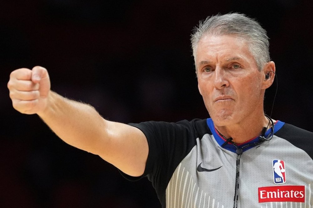 Referee Scott Foster, wearing an earpiece, signals a call during the second half of a preseason NBA basketball game between the Miami Heat and the Milwaukee Bucks, Monday, Oct. 6, 2025, in Miami. (AP Photo/Rebecca Blackwell)