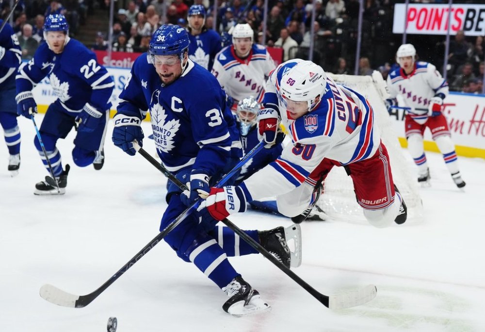 Maple Leafs captain Auston Matthews battles for the puck with New York Rangers winger Will Cuylle in Toronto on Thursday, Oct. 16, 2025. THE CANADIAN PRESS/Nathan Denette