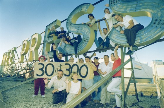 Staff gather on the Free Press sign on last day of the Winnipeg Free Press building at 300 Carlton St. before moving to 1355 Mountain Ave. (Free Press files)