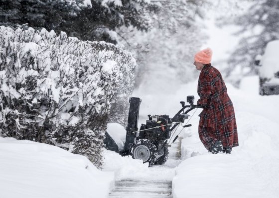 A resident uses a snowblower to clear a driveway in Cremona, Alta., on Monday. (Jeff McIntosh / The Canadian Press)