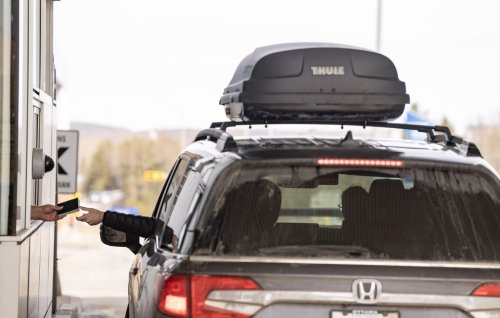 A Canada Border Services officer hands passports back to visitors entering Canada from Vermont at the Highway 55 Port of Entry in Stanstead, Que., Thursday, March 13, 2025. THE CANADIAN PRESS/Christinne Muschi