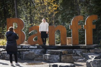 Tourists pose for photos on the icon Banff sign in Banff, Alta., Thursday, Oct. 17, 2024. The town moved the sign to a new location Thursday, Nov. 20. THE CANADIAN PRESS/Jeff McIntosh