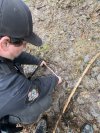 A B.C. conservation officer measures a footprint in the mud during the search in Bella Coola on Saturday Nov. 22, 2025, for a bear that attacked a group of children and their teachers. THE CANADIAN PRESS/Handout — B.C. Conservation Officer Service

(Mandatory Credit)